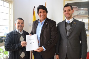 O diretor Daniel Galiano, o franqueado Hugo Oliveira e o assessor jurídico Junior Landin com o novo contrato